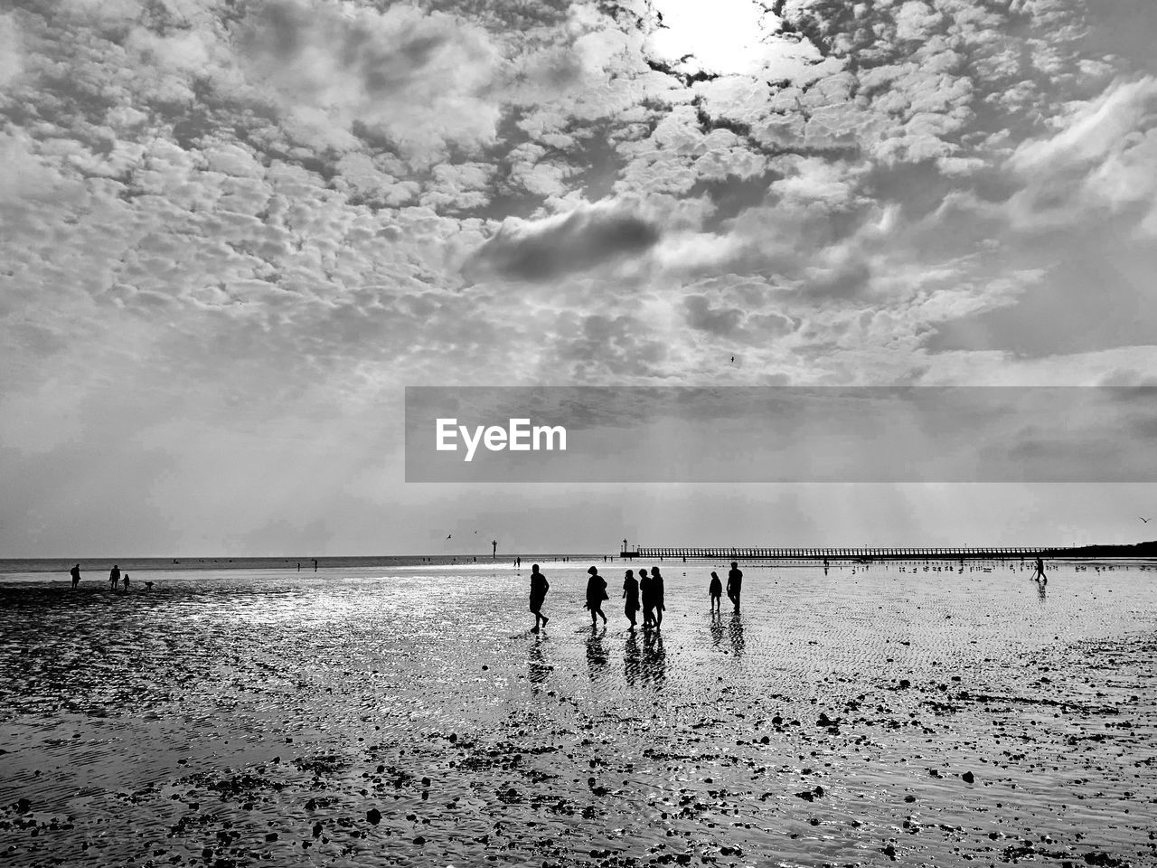 PEOPLE ON BEACH AGAINST SEA