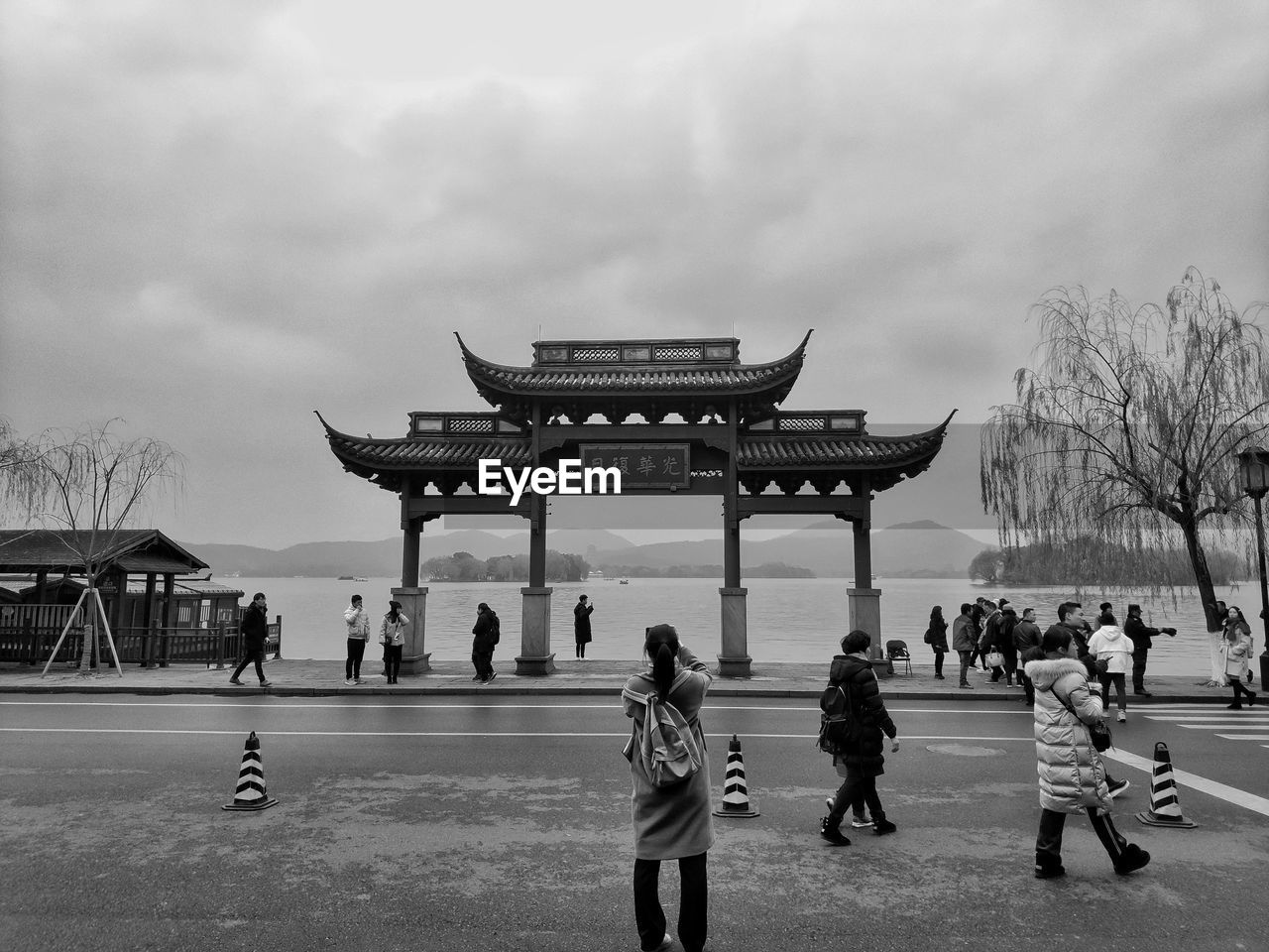 Group of people in front of building against cloudy sky