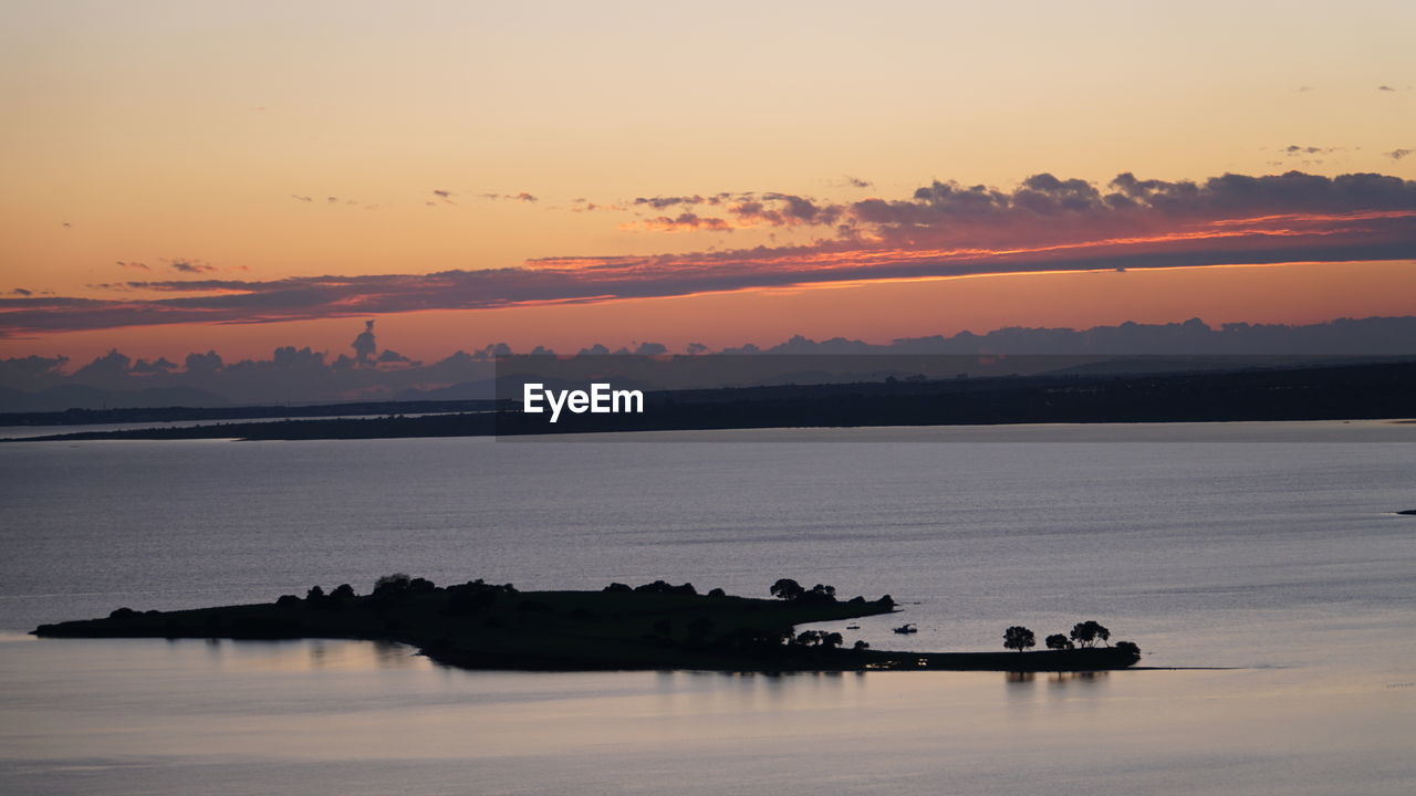 SILHOUETTE BOAT IN SEA AGAINST ORANGE SKY