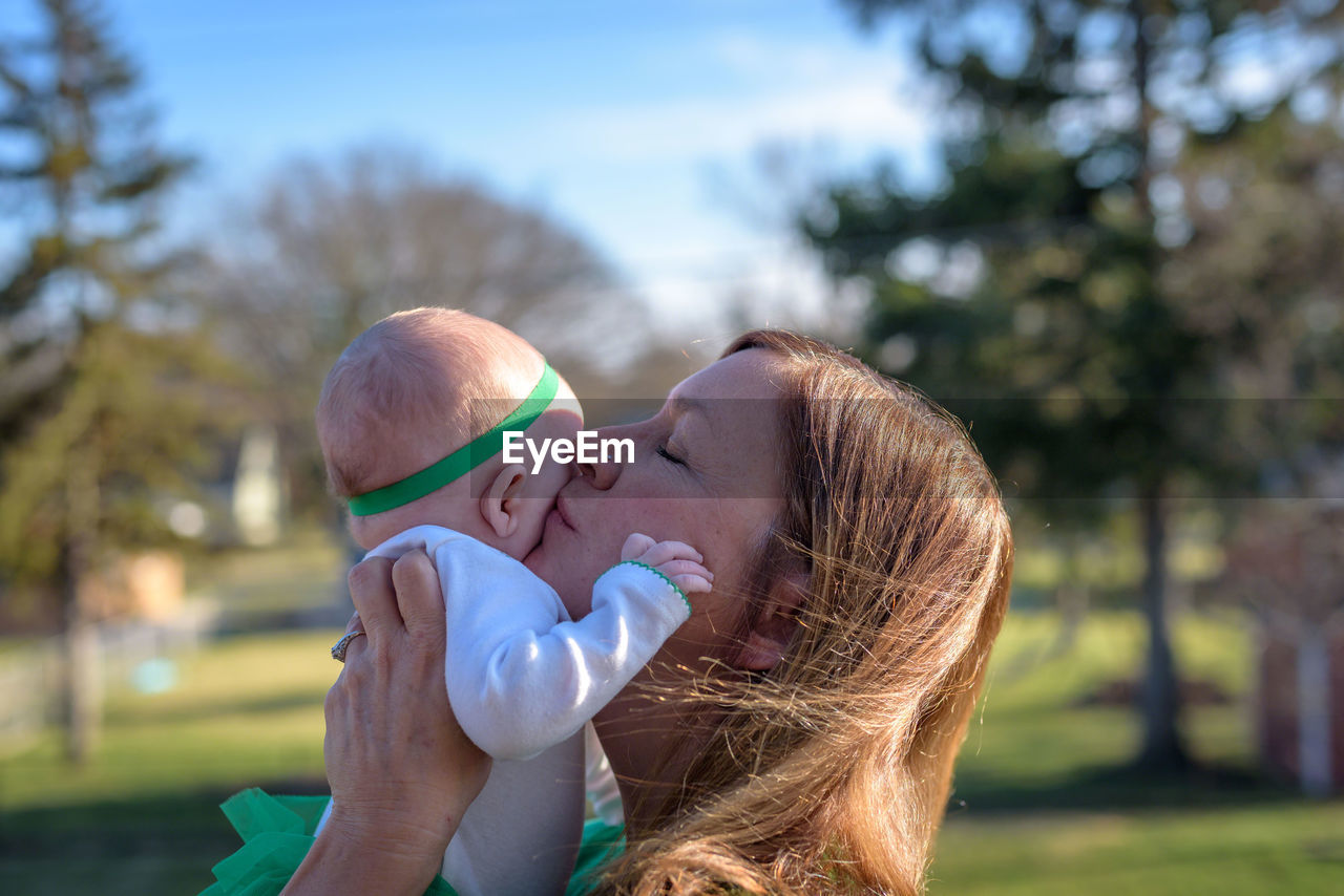 Close-up of mother carrying baby at park