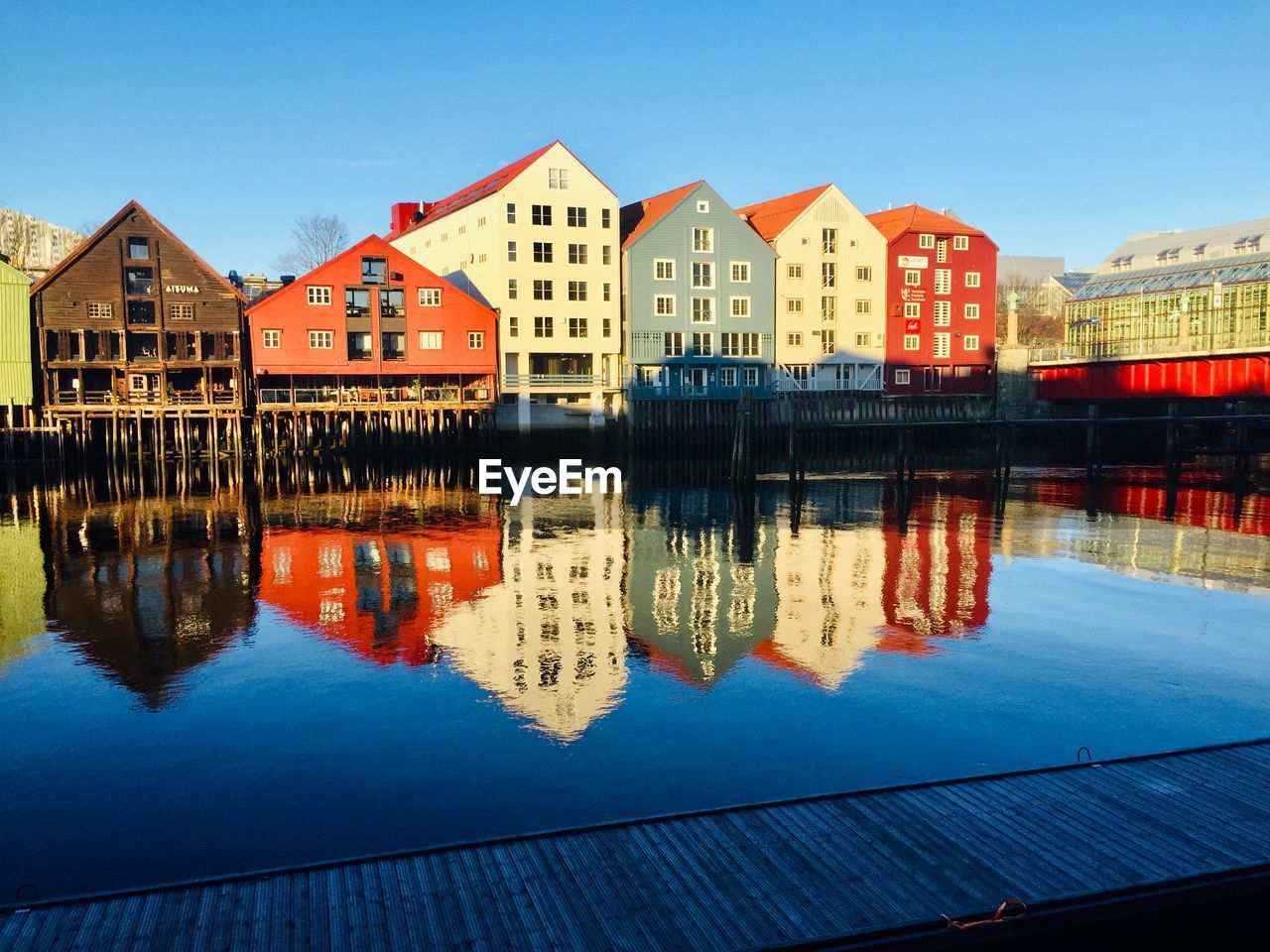 Reflection of buildings in lake against blue sky