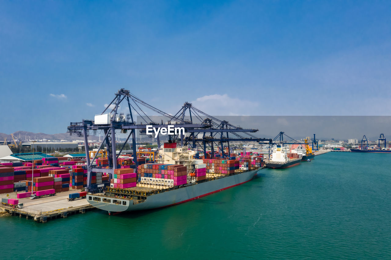 Commercial dock and cranes with shipping containers at harbor 