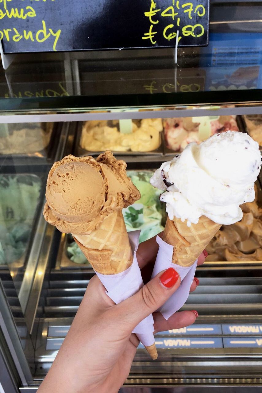 Cropped hand holding ice cream cones at store