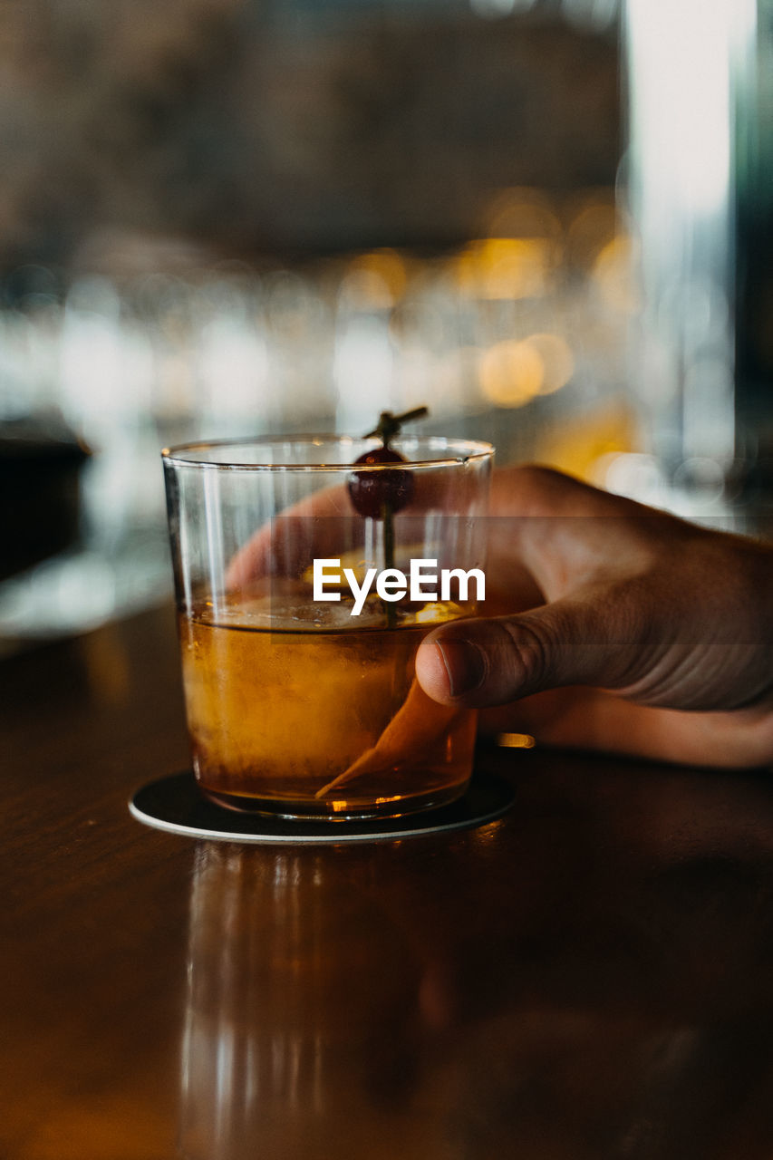 Midsection of woman drinking glass on table