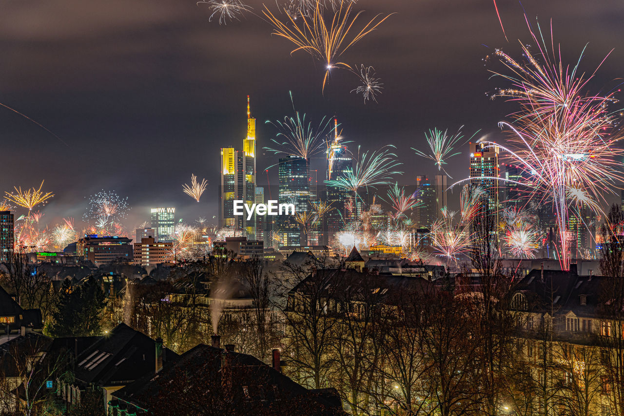 Firework display over illuminated buildings in city at night