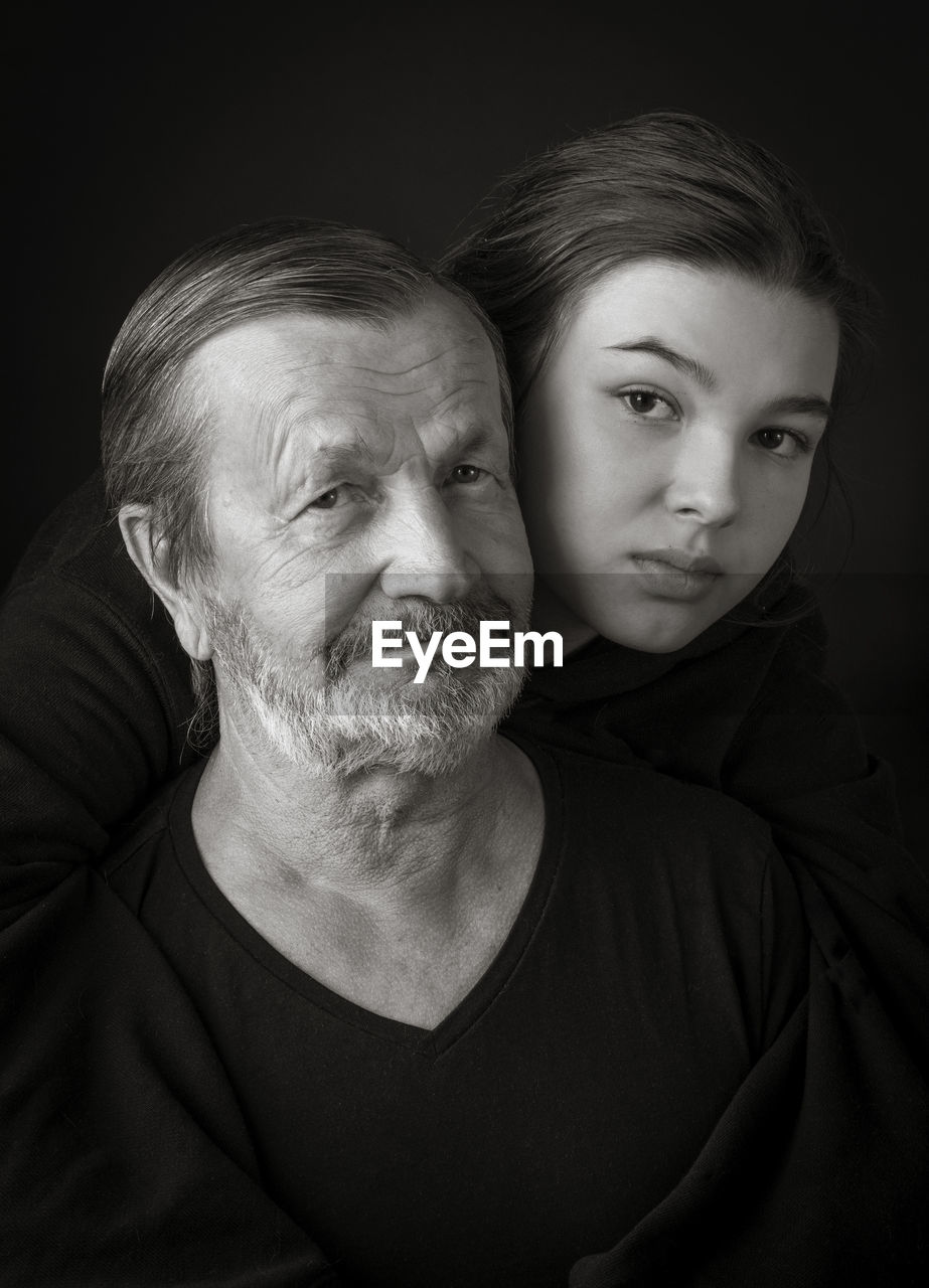 Elderly man and his granddaughter teen girl