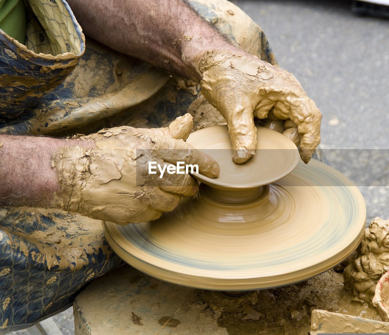 cropped hand of man making pottery at workshop