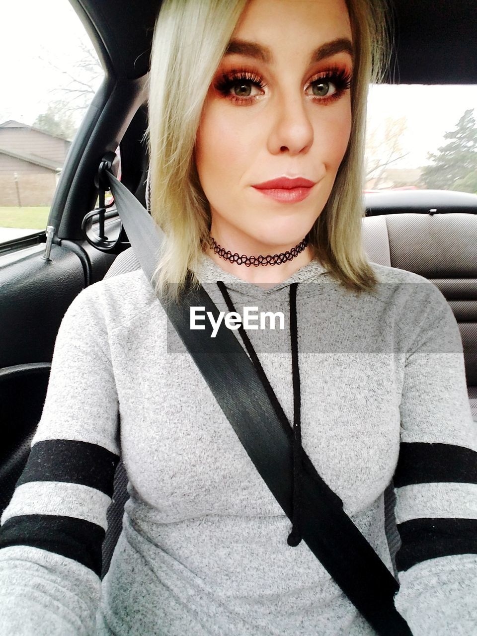 PORTRAIT OF YOUNG WOMAN IN CAR