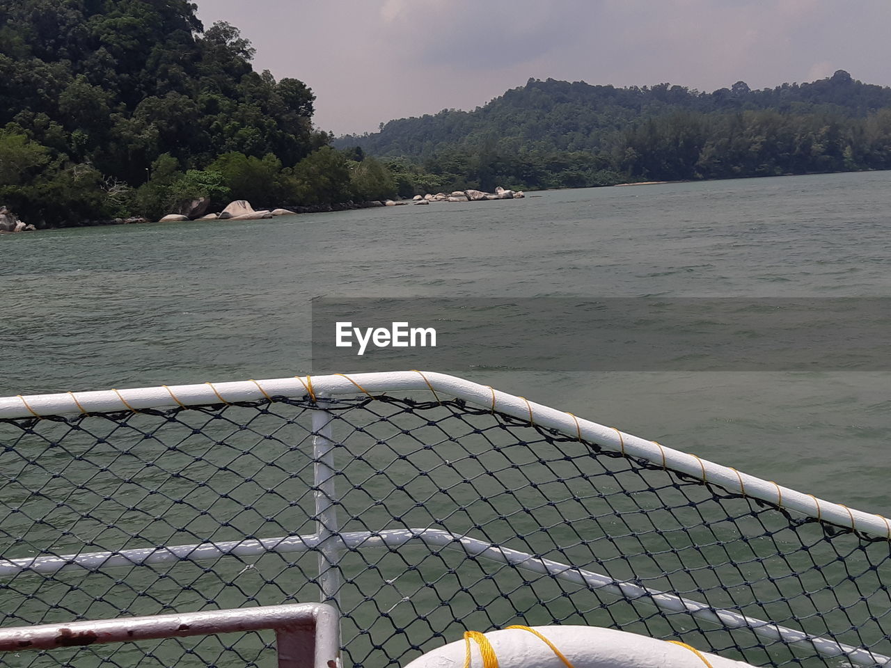 SCENIC VIEW OF RIVER SEEN THROUGH FENCE