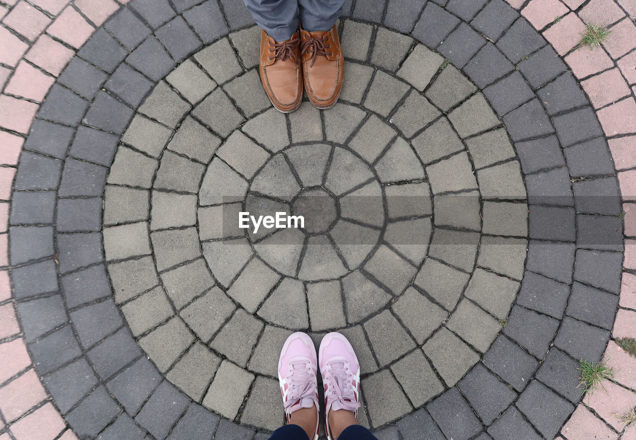 Low section of friends standing on cobblestone