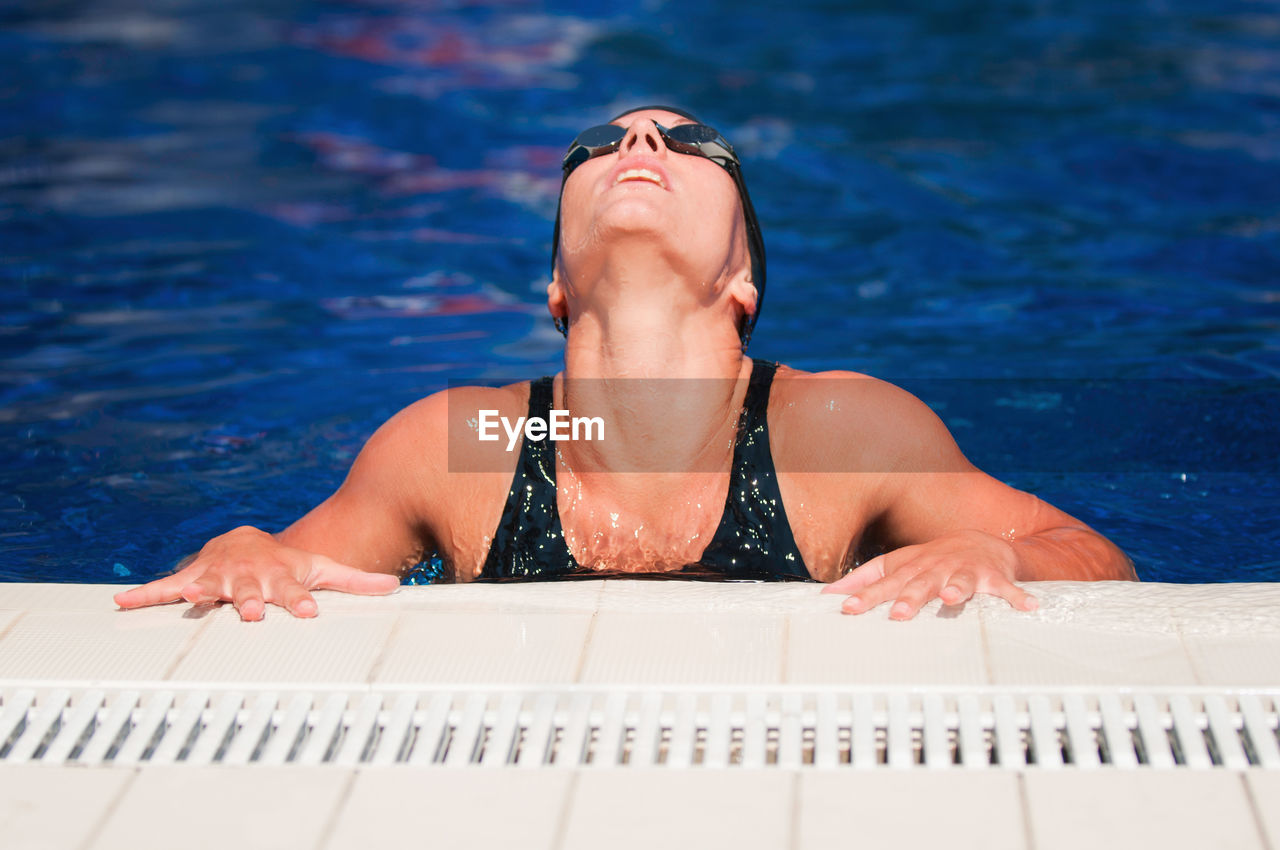 High angle view of mid adult woman relaxing at poolside