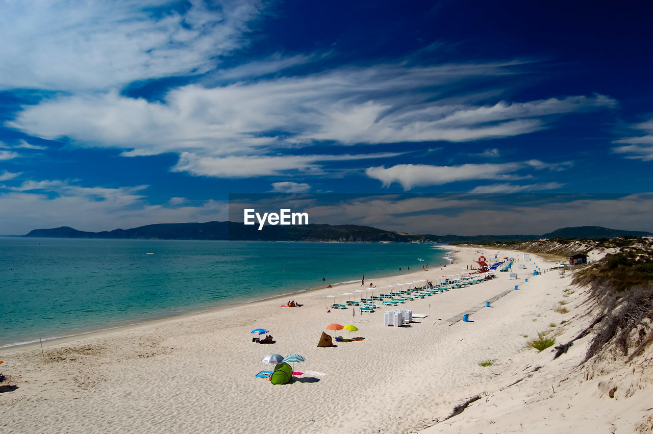 group of people at beach against sky