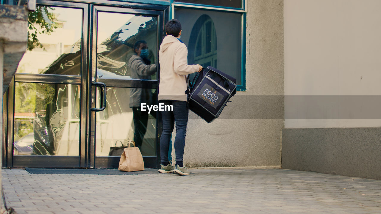 rear view of woman standing in city