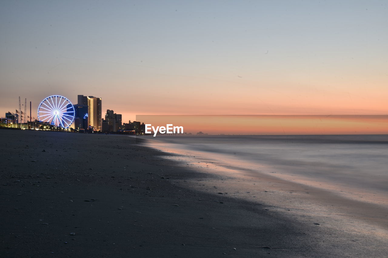 Scenic view of beach against sky during sunrise