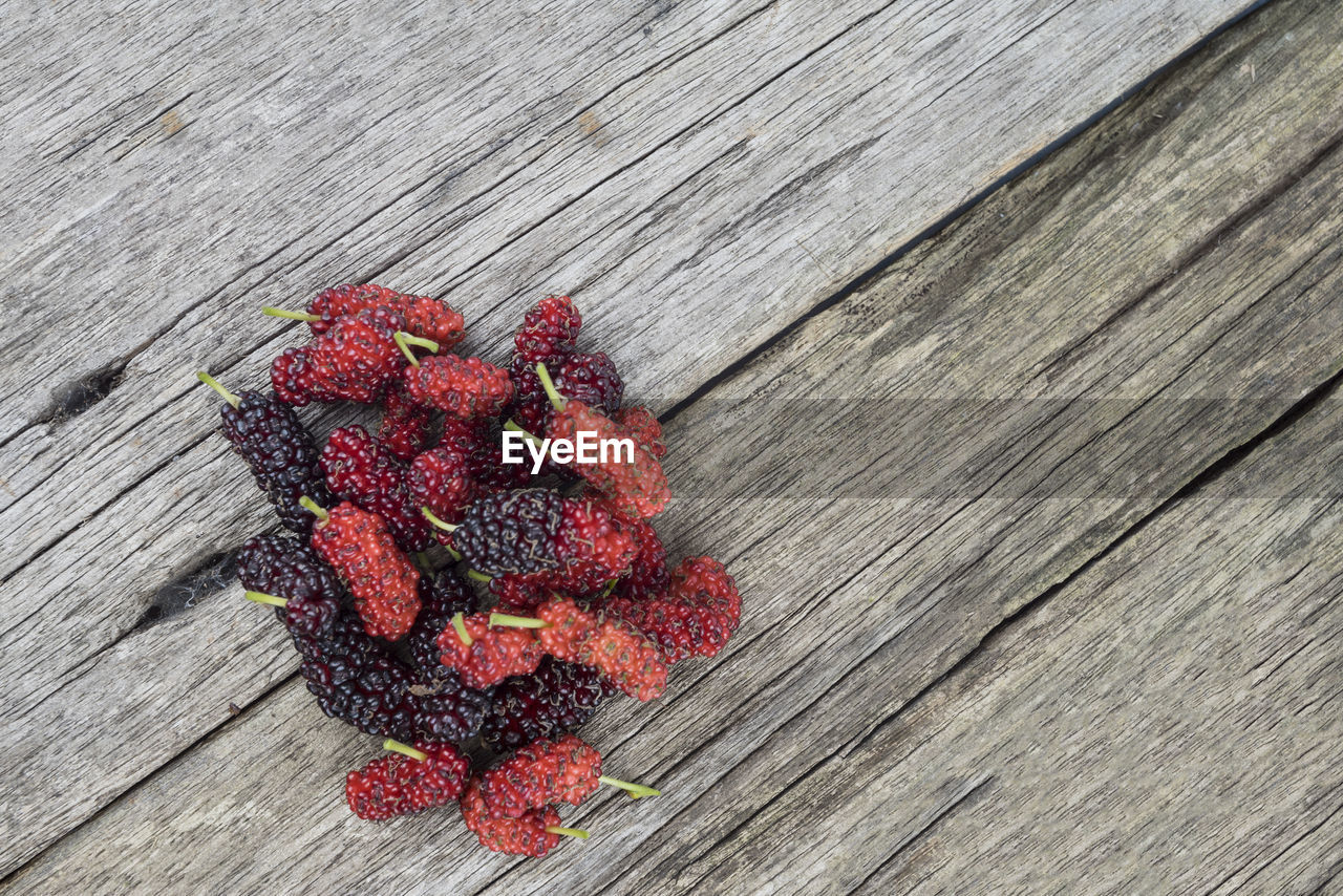 HIGH ANGLE VIEW OF RED BERRIES ON TABLE