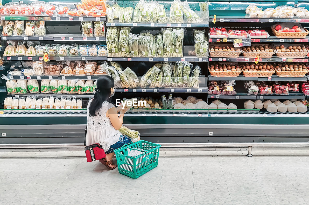 FULL LENGTH OF WOMAN SITTING ON STORE