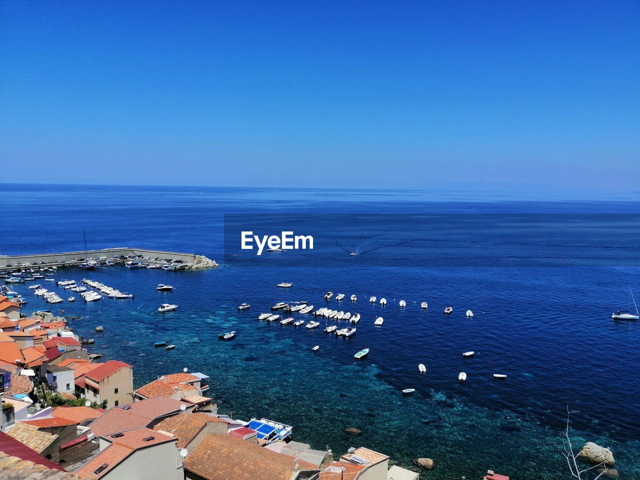 Scenic angle view of sea against clear blue sky