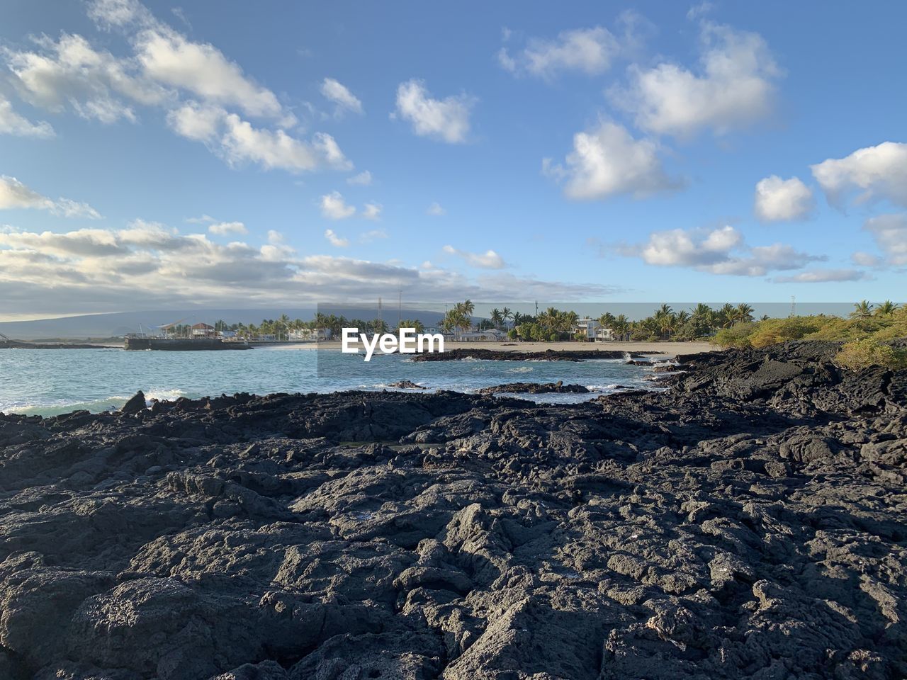Scenic view of volcanic lava rocks by the sea against sky on isabela island galapagos 