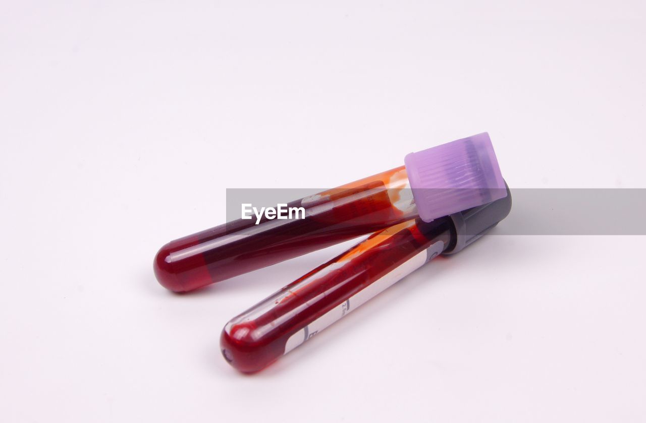 High angle view of blood bottles on white background