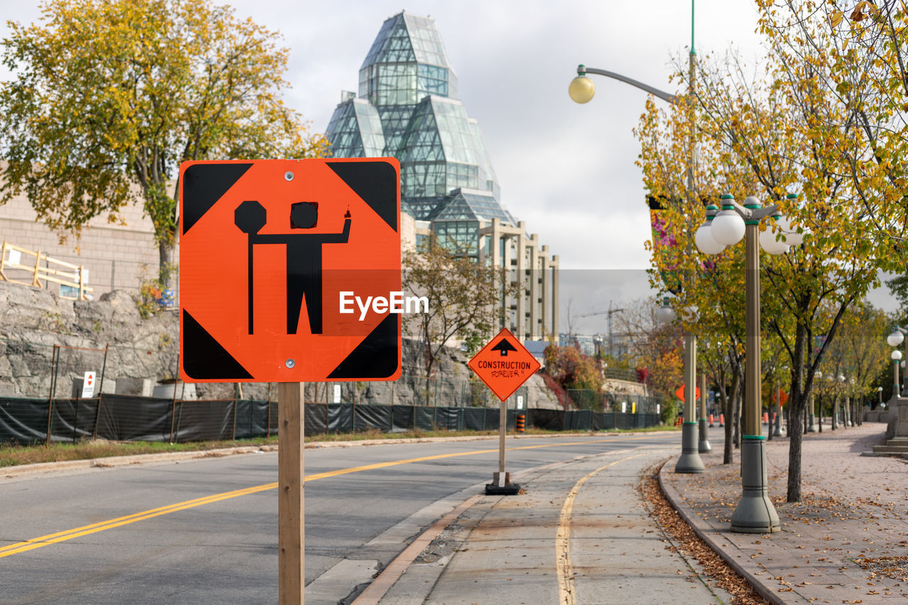 Traffic control person ahead road sign due to construction work in downtown of ottawa, canada