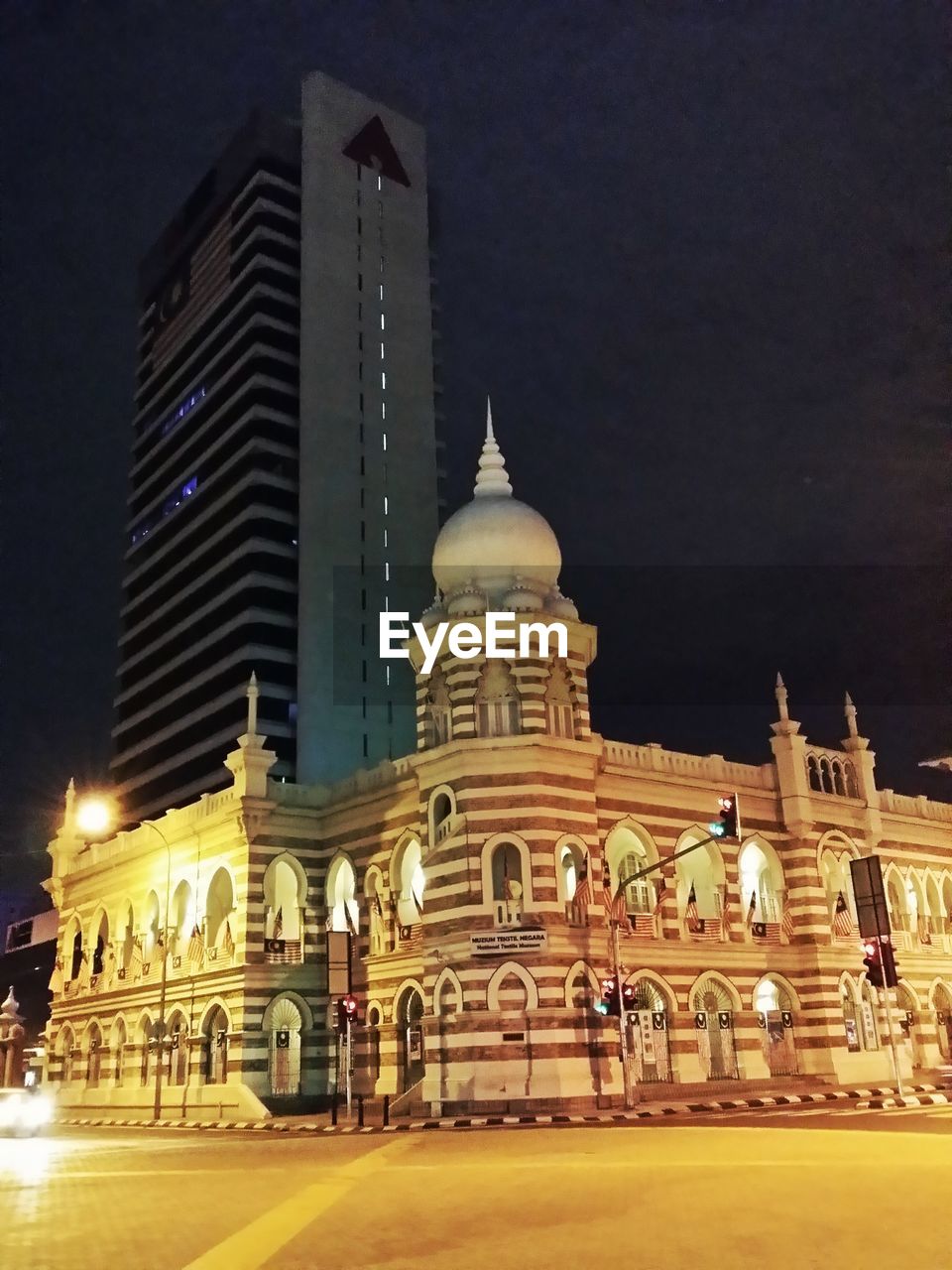 LOW ANGLE VIEW OF ILLUMINATED BUILDING AT NIGHT