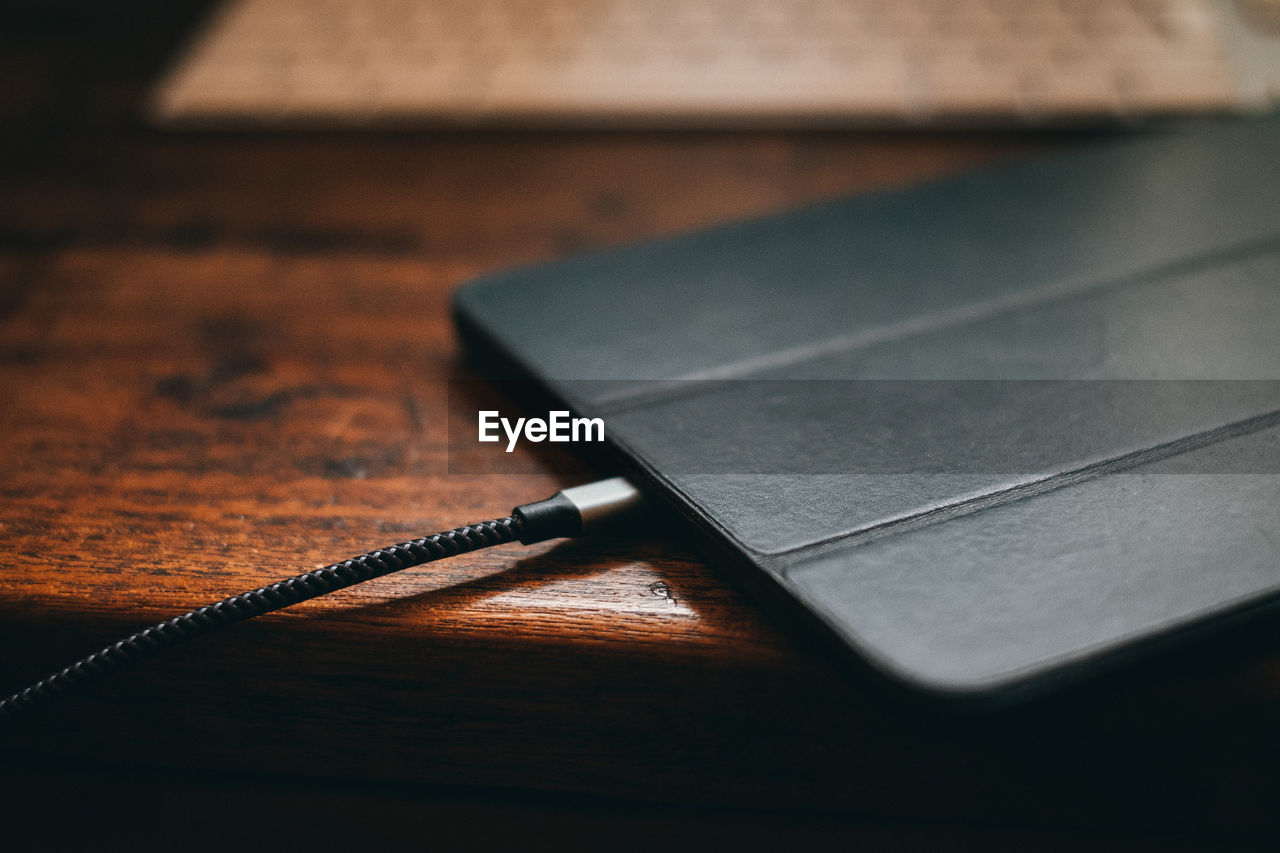 Close-up of mobile phone charging on table