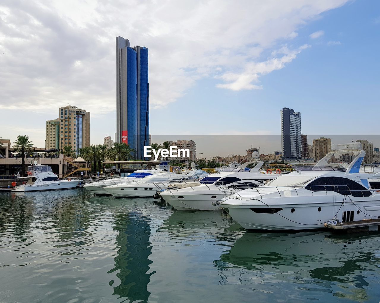 BOATS MOORED ON SEA BY BUILDINGS AGAINST SKY