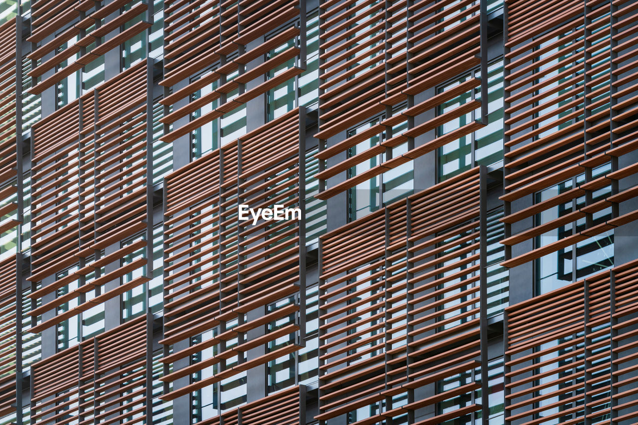 LOW ANGLE VIEW OF MODERN GLASS BUILDING IN CITY