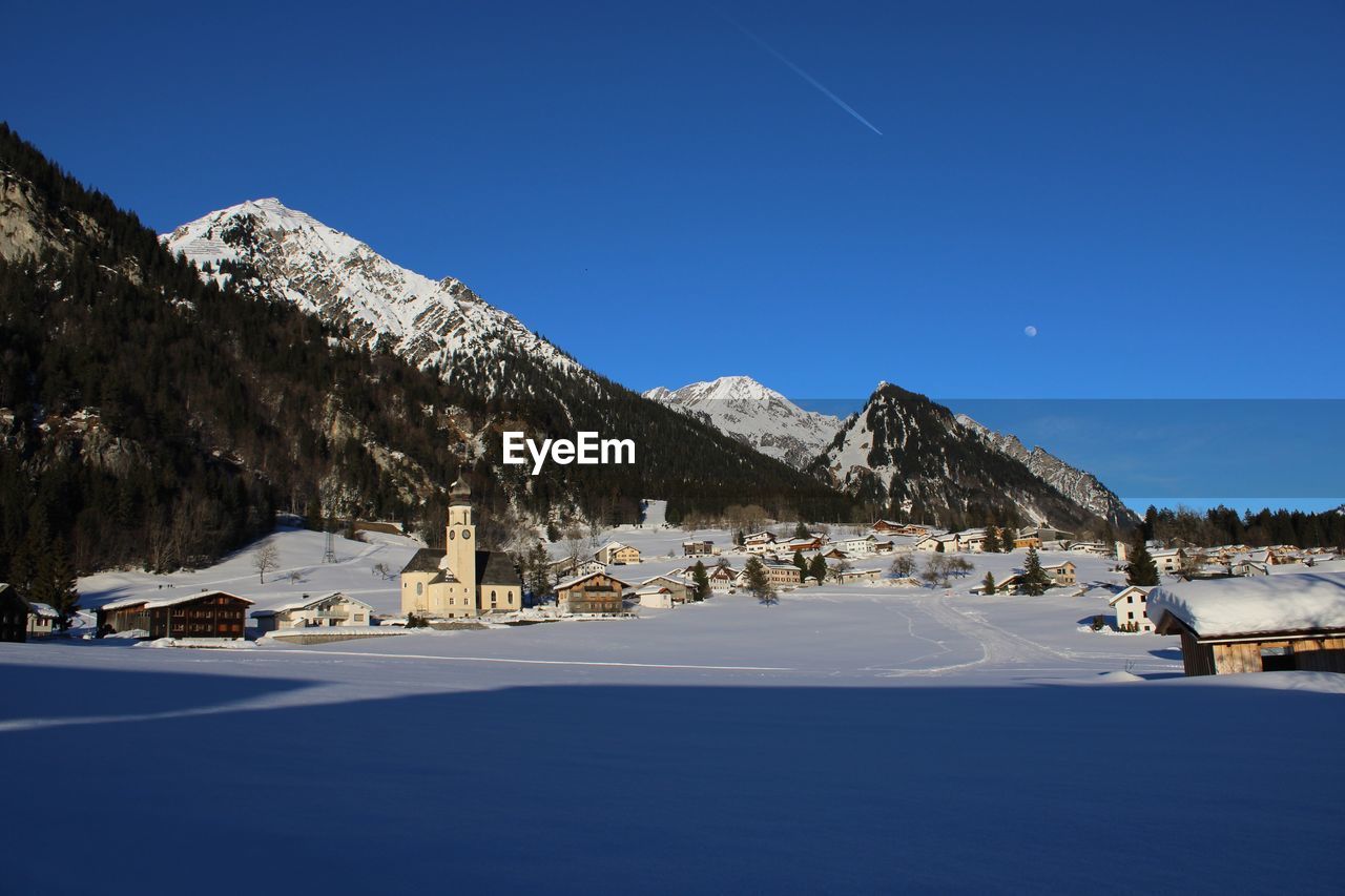 Scenic view of snowcapped mountains against clear blue sky