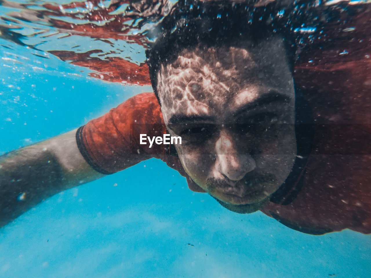 CLOSE-UP PORTRAIT OF MAN SWIMMING IN SEA