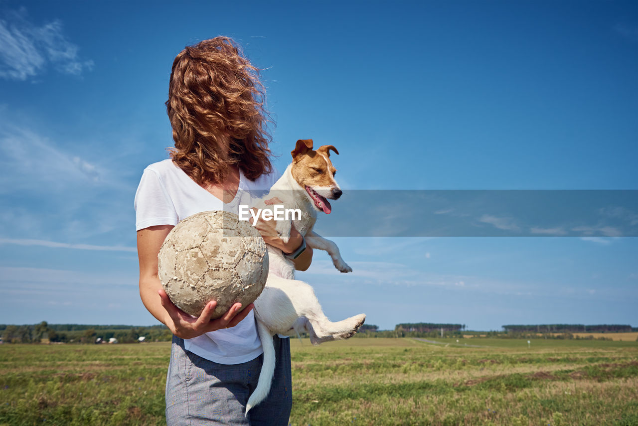 Woman have fun with her dog in summer day outdoors. friendship owner with pet