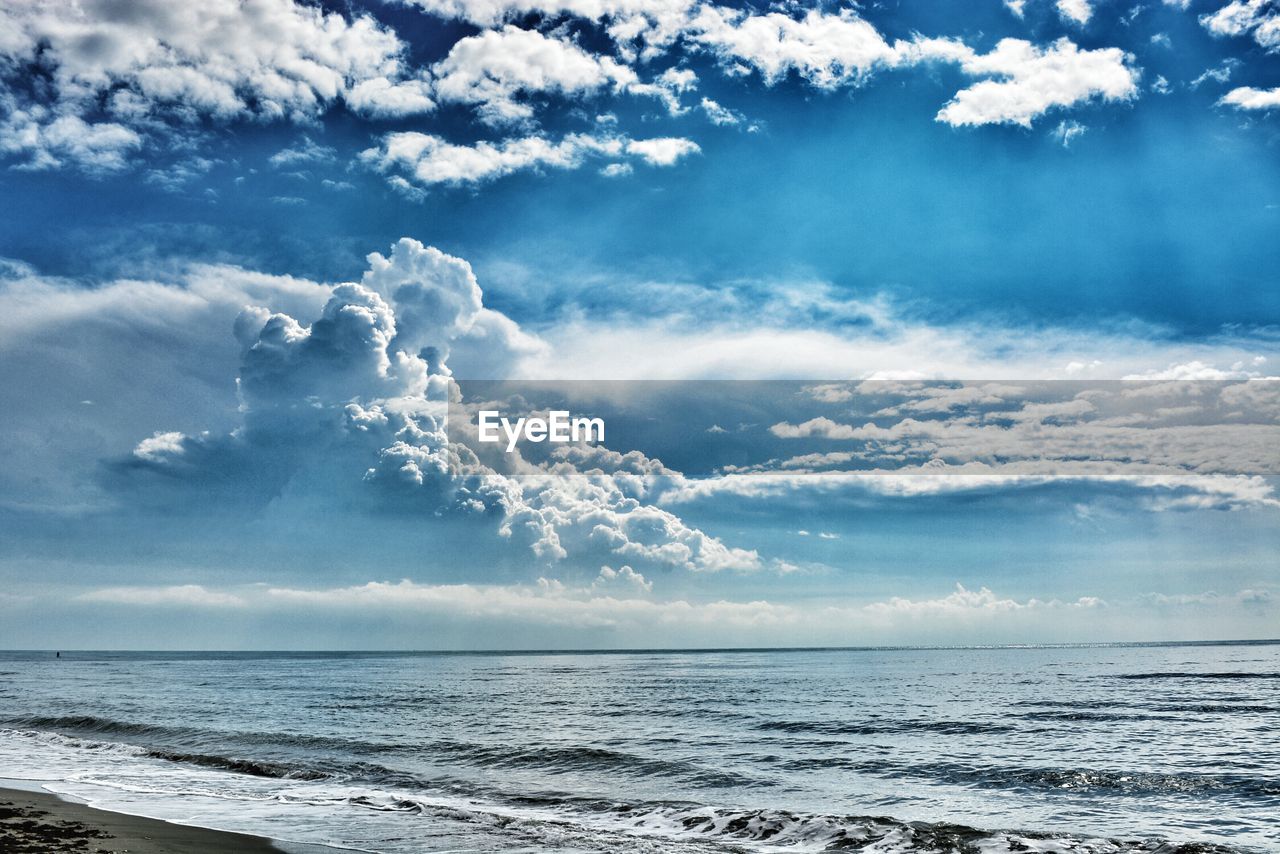 Scenic view of beach against cloudy sky