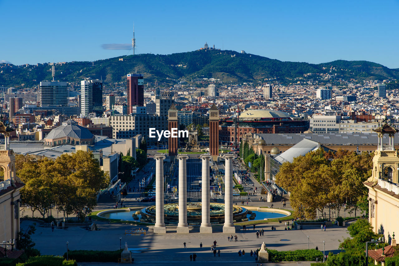 HIGH ANGLE VIEW OF CITY BUILDINGS AGAINST CLEAR SKY