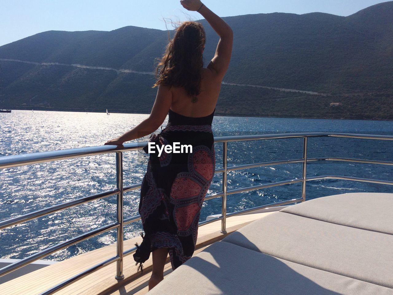 Young woman standing on boat sailing in sea