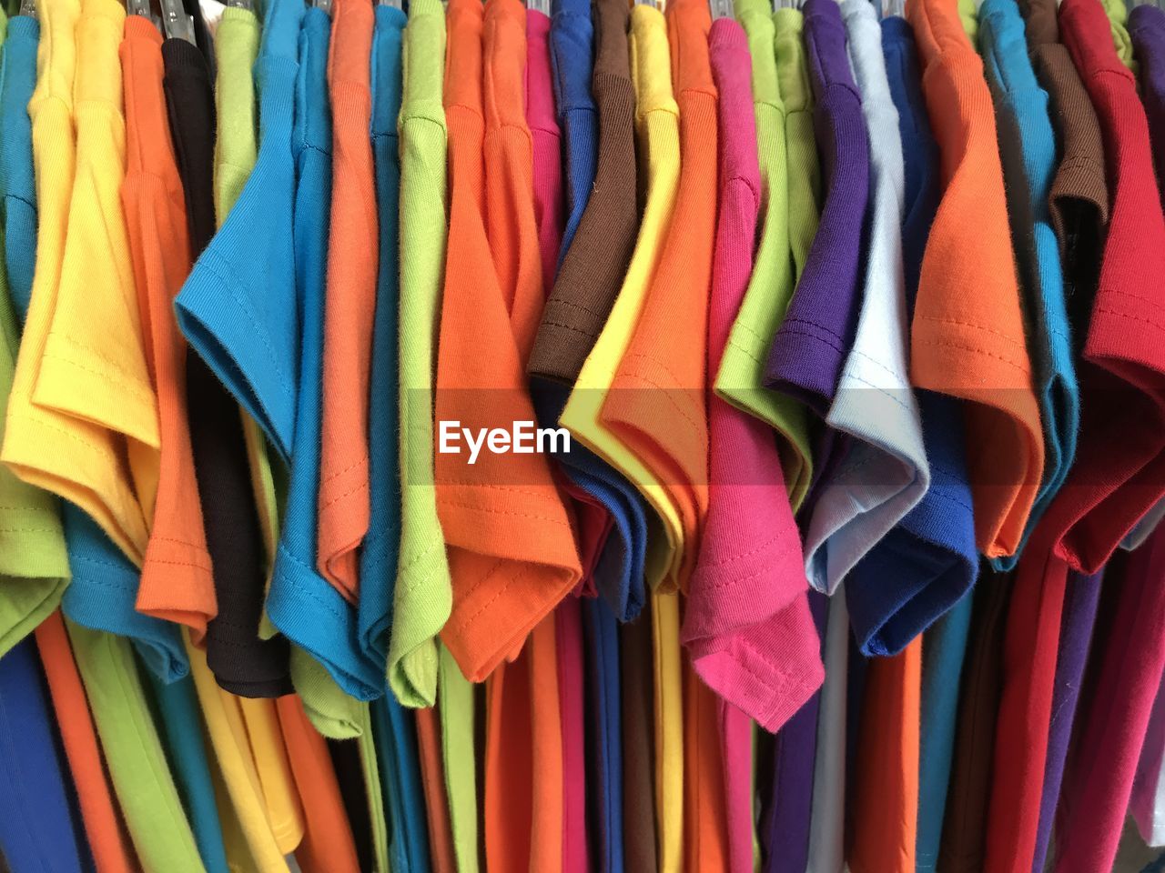 Multi colored clothes hanging on display at store