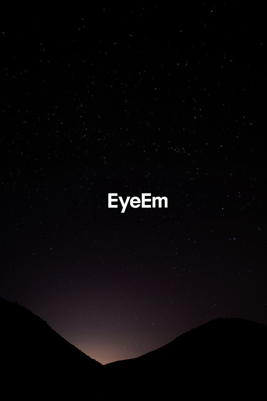 LOW ANGLE VIEW OF MOUNTAIN AGAINST SKY AT NIGHT