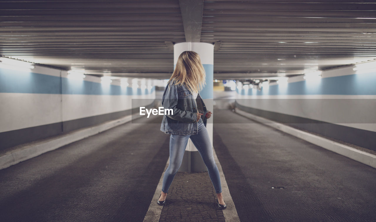 Woman standing in illuminated subway station