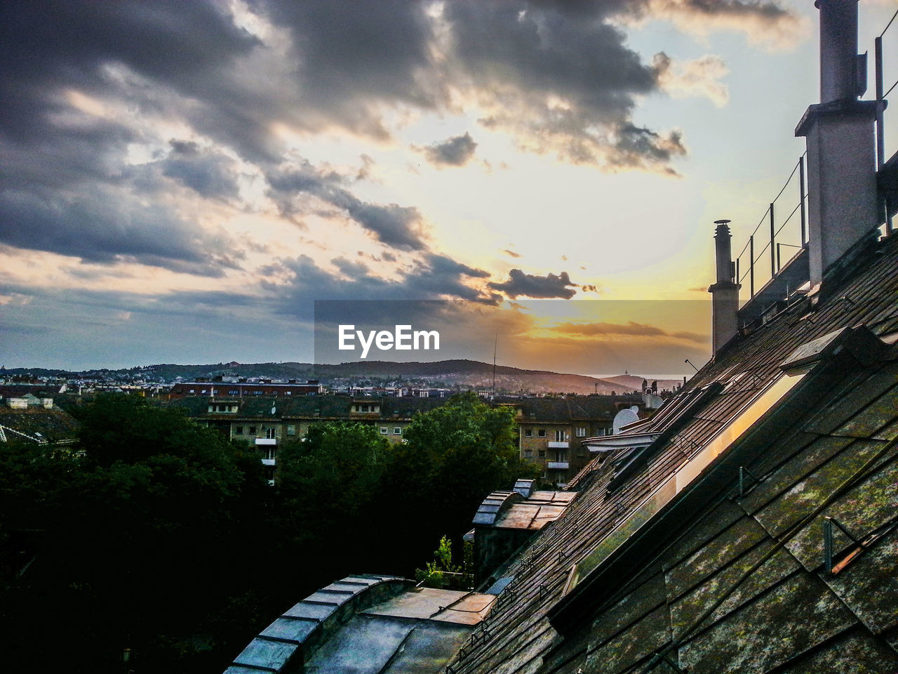 View of cityscape seen from roof against cloudy sky
