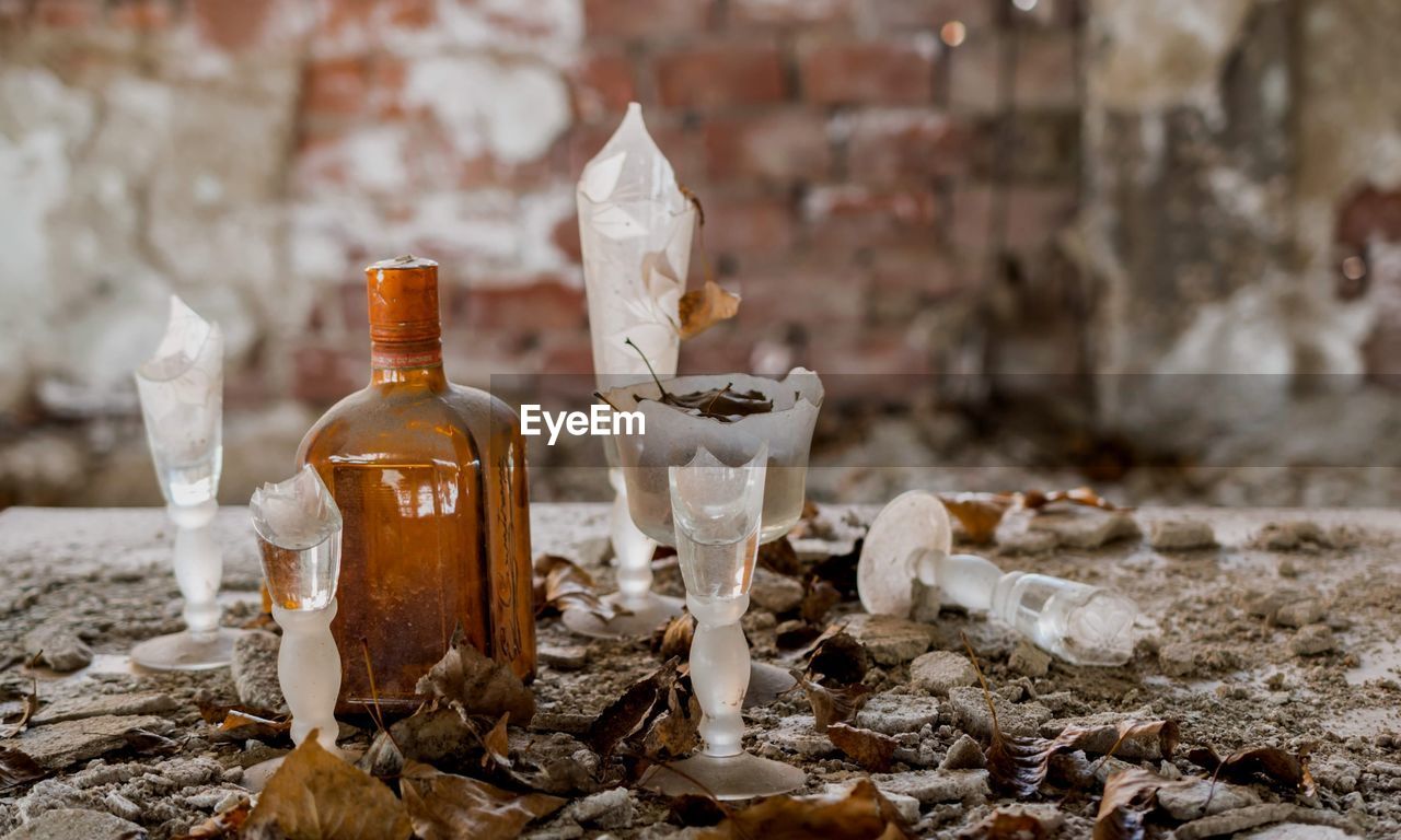 CLOSE-UP OF GLASS BOTTLES ON SHELF