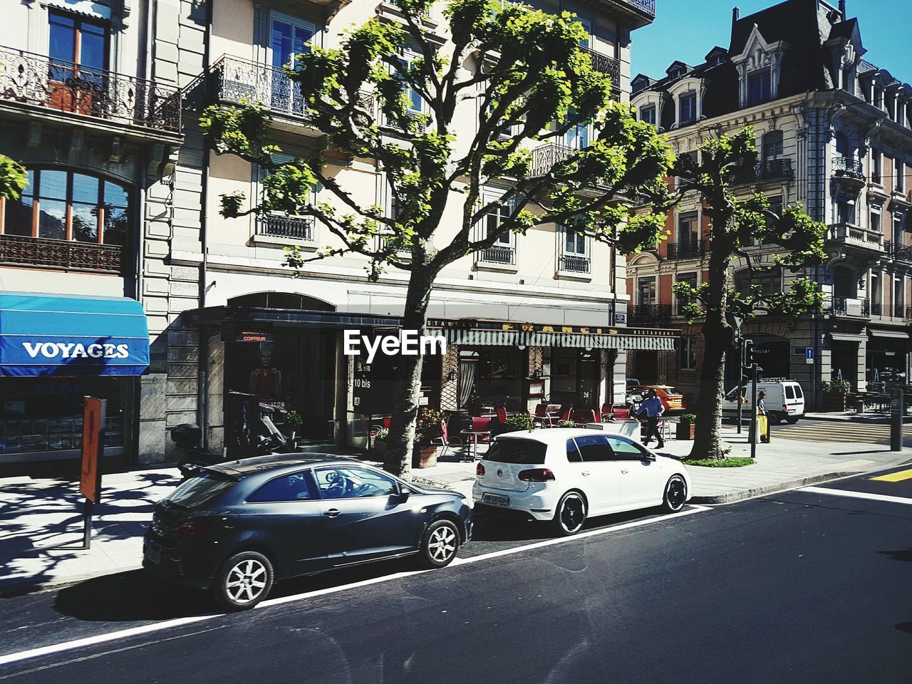 CARS ON ROAD AGAINST BUILDINGS