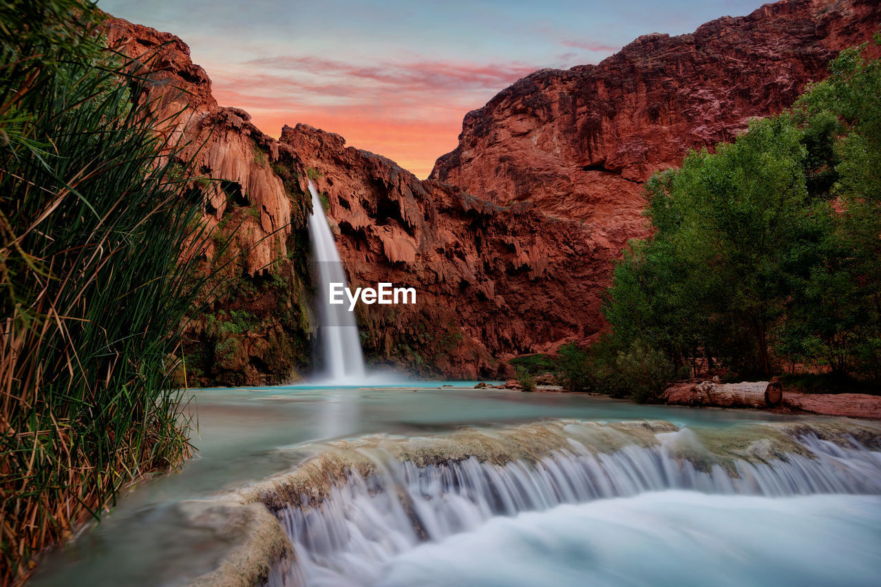 Scenic view of waterfall against mountain