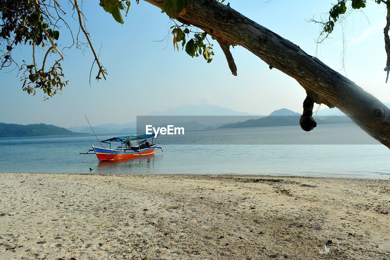 Outrigger canoe moored in sea