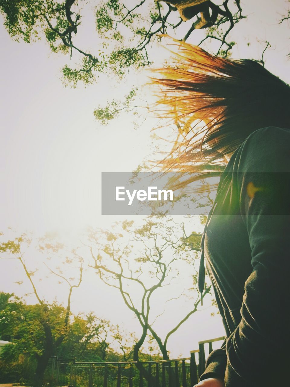 Profile shot of woman tossing her hair in park