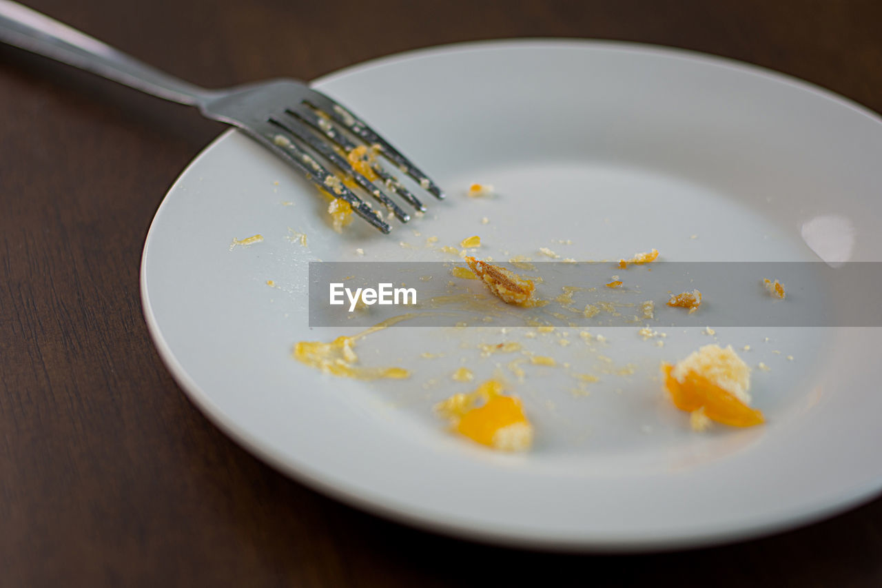 A blank white dish with a piece of candy stuck