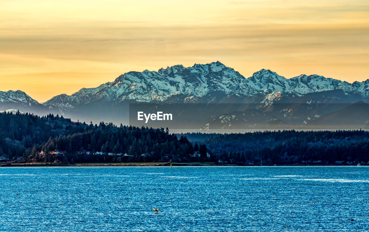 A sunset with the olympic mountains across the puget sound.