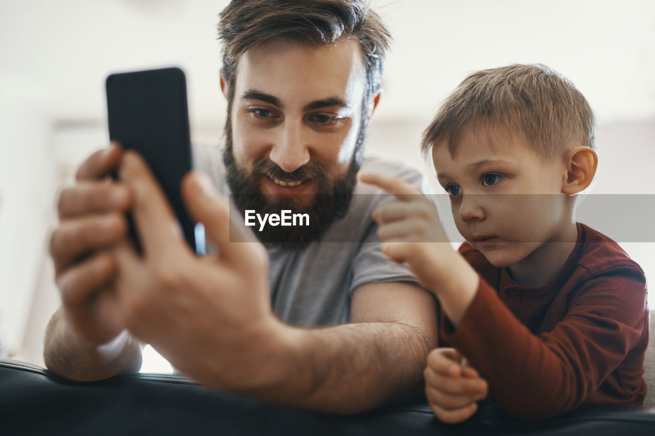 Portrait of father and little son with smartphone