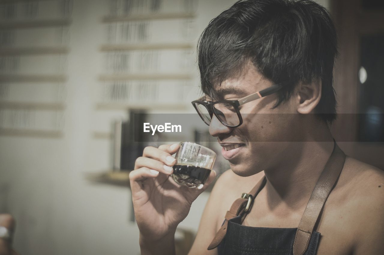 Smiling young man drinking coffee at home