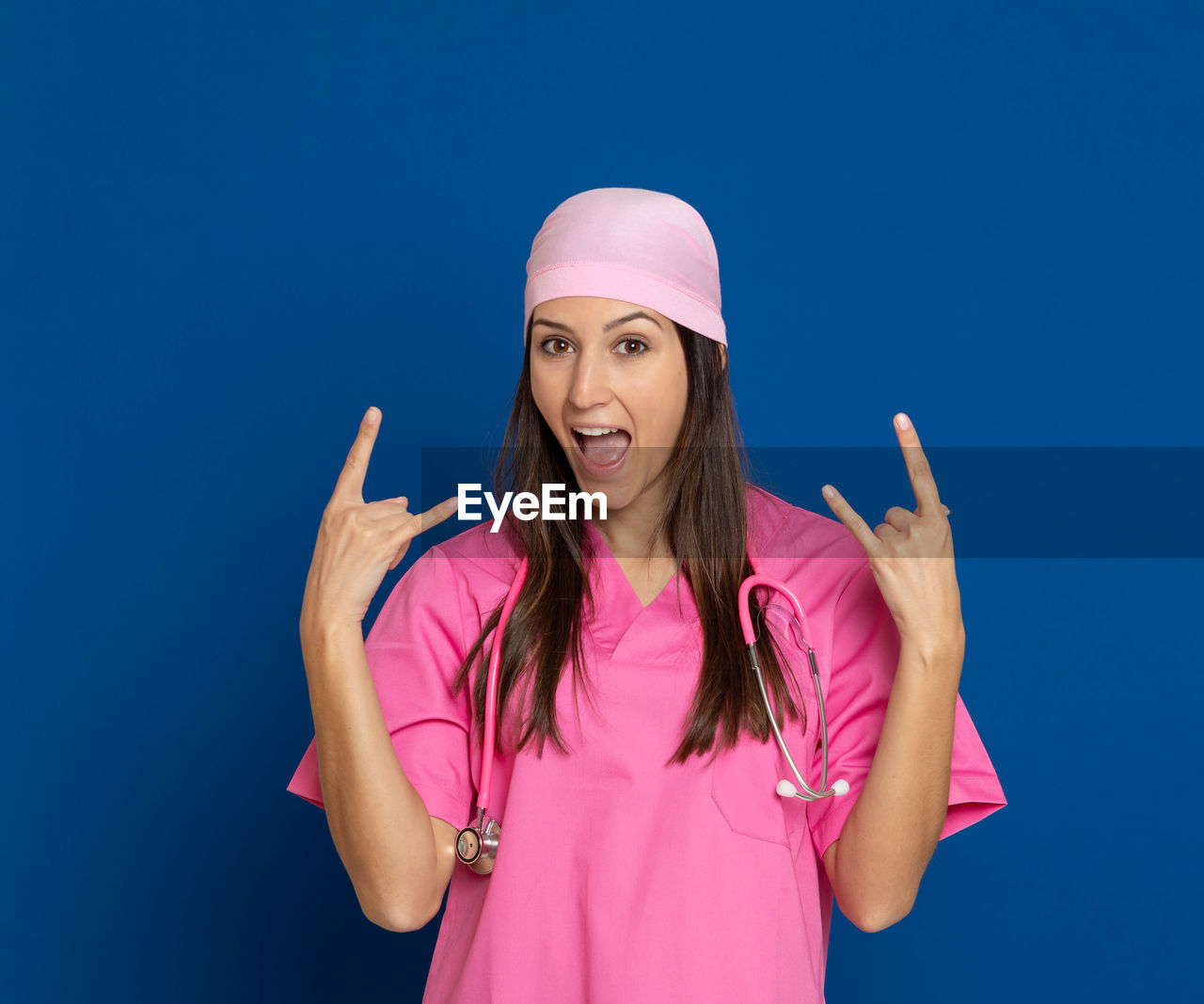 PORTRAIT OF SMILING WOMAN STANDING AGAINST PINK BLUE SKY