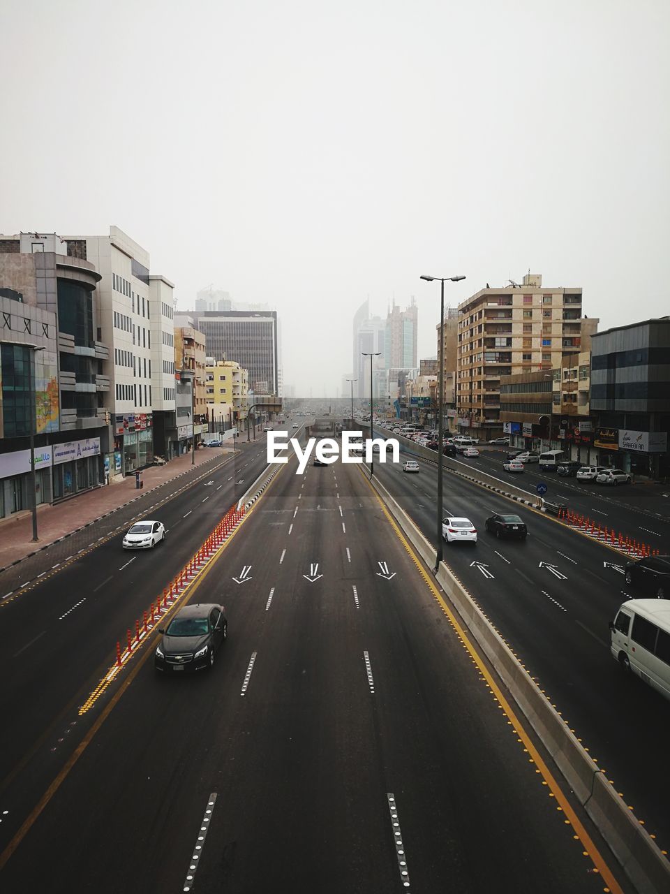 TRAFFIC ON ROAD IN CITY AGAINST SKY