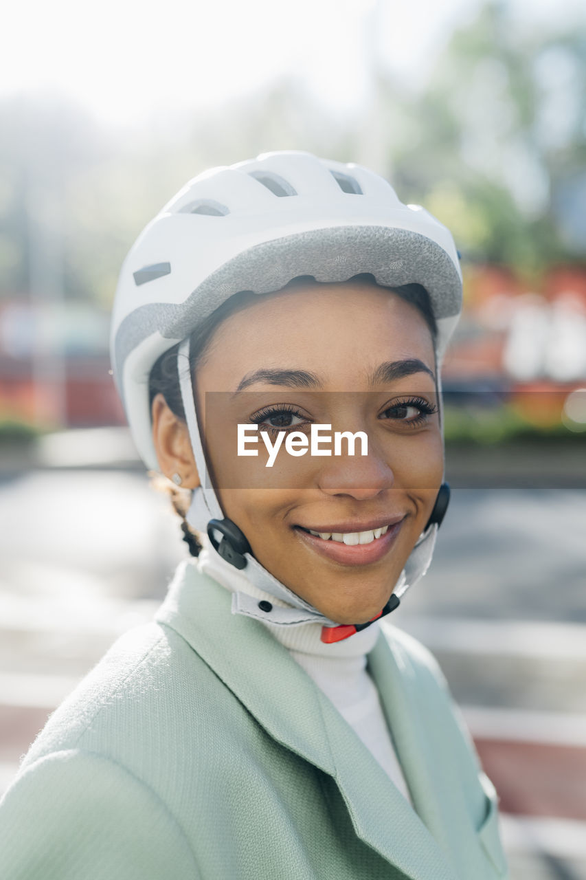 Smiling businesswoman wearing cycling helmet